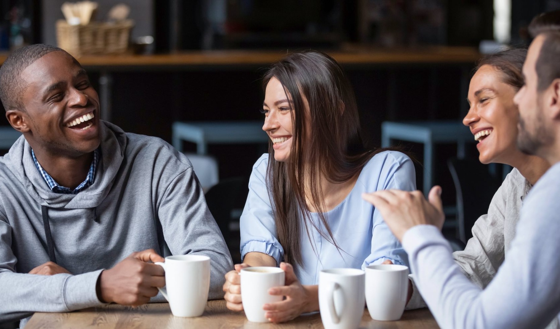 a group of people laughing with cups on a table